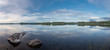Panorama of calm lake at Lapland in midnight sun time. Rocks in front.