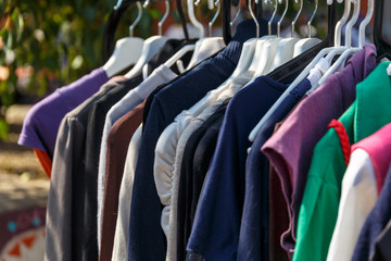 Wall Mural - Hangers with men's and women's clothing at the garage sale