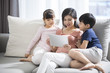 © Blue Jean Images - Happy young family using digital tablet at home