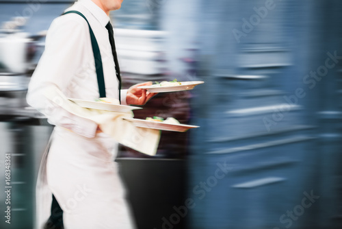 Plakat Kelner porcja w ruchu na służbie w restauracji długich ekspozycji