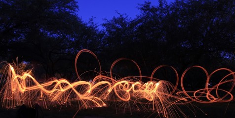 Creating fiery loops, spirals and trails of light before sunrise with steel wool photography. 