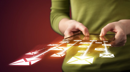 Hand holding tablet and sending email icons