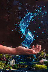 Wizard holding a moving spiral of clear water on their hand. Dark still life with magic of nature.