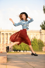 Canvas Print - Beautiful young woman jumping outdoors