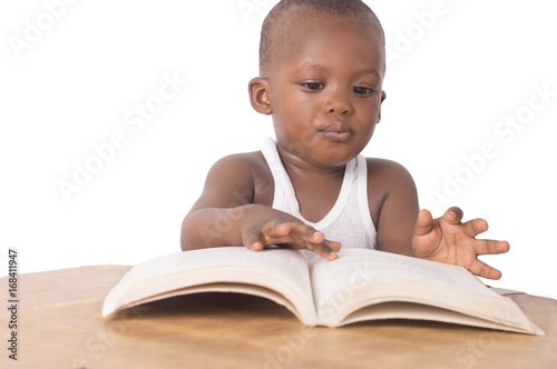 Fotografie, Obraz petit garçon assis entrain de lire un livre