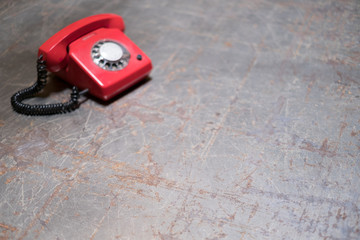  table with red phone in background - telephone on desk