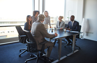 Work colleagues discussing business together in an office boardroom