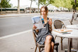 © rh2010 - Young stylish woman reading journal sitting outdoors at the cafe in Paris