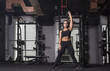 © Paul - Beautiful, athletic female performs  an over head lift with a kettlebell swing wearing black sports outfit showing her abs