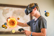 A teenage student wearing a virtual reality headset to study science.