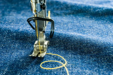 Wall Mural - Macro picture of sewing machine parts as follows needle and presser foot on jean fabric.