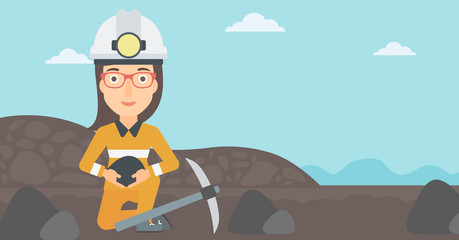 Wall Mural - A woman sitting with coal in hands and a pickaxe on the background of coal mine vector flat design illustration. Horizontal layout.