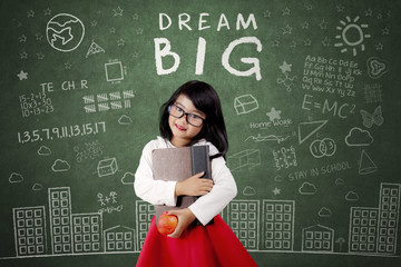 Child with Dream Big text on chalkboard