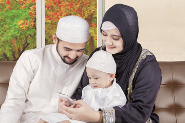 Canvas Print - Muslim family using smartphone with autumn