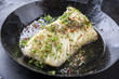 Fried cod fish fillet with spice and cress as close-up in a cast iron pan