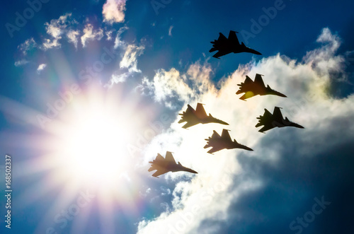 Fotografia Group of fighter jet airplane sun glow blue sky