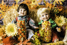 Autumn Scene With Two Child Dolls With Halloween Candy And Fall Foliage   