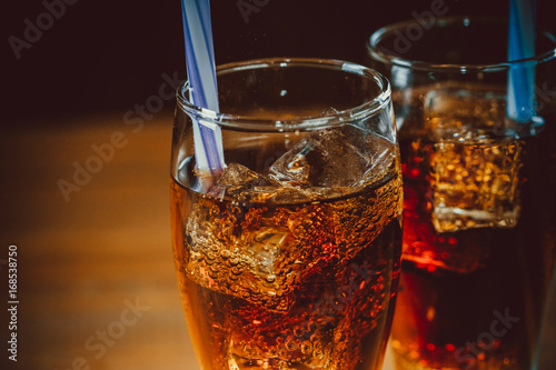 Fotomural Hermosa bebida fría de Cola con cubitos de hielo con una caldera paja en vasos s