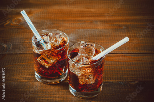 Fotomural Hermosa bebida fría de Cola con cubitos de hielo con una caldera paja en vasos s