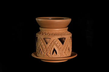 Isolated terracotta stove for aromatherapy on black background