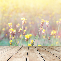 Wall Mural - Wood table top and blurred flowers background with vintage filter