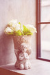 Flower pot, there is a white rose, Cupids, placed by the window. Vintage home decoration