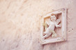 Ceramic picture frame with a cute winged cupid statue. Stuck on the wall A vintage decoration