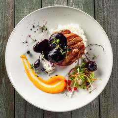 Wall Mural - Delicious meat steak with rice, salad and sauce on a plate. Lunch healthy meal made of grilled meat and vegetable salad on a wooden table. Top view.