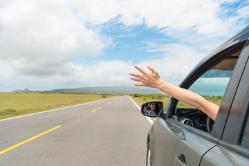 girl sitting on travel car happily reach out hand