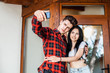 © mikhail_kayl - Happy romantic couple taking a photo with smart phone. Beautiful young girl and man hug and laugh taking a selfie. Urban fashion style