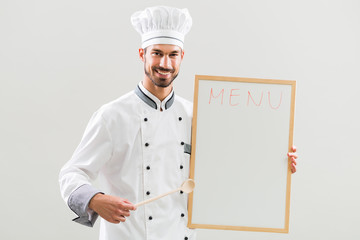 Wall Mural - Chef  is showing whiteboard on gray background.