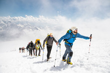 A Group Of Mountaineers Climbs To The Top Of A Snow-capped Mountain