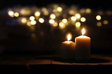 Burning Candles Over Old Wooden Table With Bokeh Lights