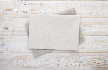 Napkin white. Stack of grey dish towels on white wooden table background top view, mock up.