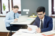 © pressmaster - Concentrated young managers in formalwear preparing financial accounts on computers while sitting at modern open plan office