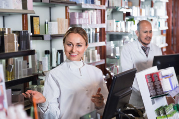 Wall Mural - Female and male pharmacists working the pharmaceutical store