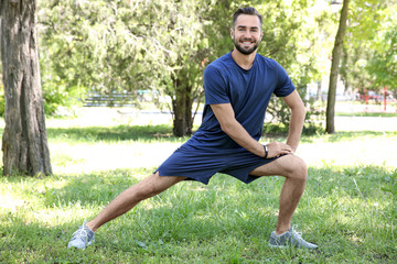 Sticker - Sporty young man doing sport exercises for legs in park