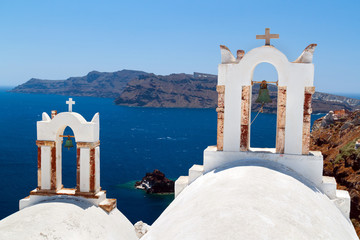 Wall Mural - Bell tower of church above blue bay at Santorini,Greece