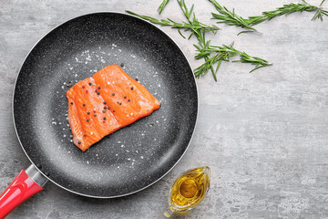 Wall Mural - Frying pan with slice of salmon and spices on light table