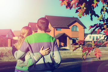 Wall Mural - Rear view of young couple looking at their new house