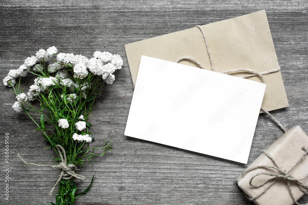 blank white greeting card with white flowers bouquet and envelope with ...