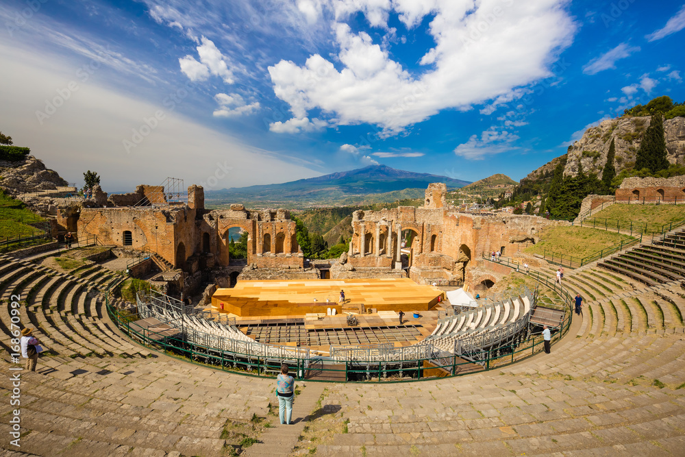 Panoramic view of beautiful town of Taormina with its greek amphitheatre and Etna volcano background, Sicily island, Italy - obrazy, fototapety, plakaty 
