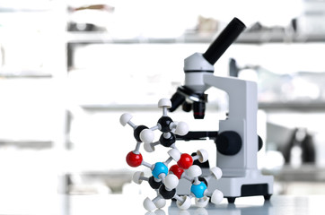 Wall Mural - Microscope with molecule model in lab