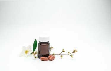 Poster - three orange vitamin and supplement capsule pills with flower and branch and blank label amber glass