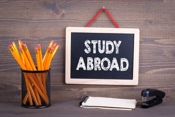 Wall Mural - Study Abroad concept. Chalkboard on a wooden background.