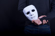© zephyr_p - Mystery man holding white mask in the back. Anonymous social masking concept.