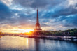 The Eiffel Tower at sunrise. Paris, France. Beautiful skyline of with rising sun and dramatic clouds.