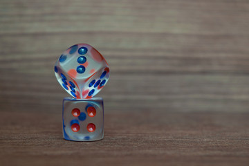 Wall Mural - Two transparent dices on each other on wooden board. Six sides with blue and red points.