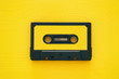 Leinwandbild Motiv Retro cassette tape over yellow wooden table. top view.