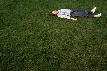 Wall Mural - beautiful young european woman lays down on grass and rests